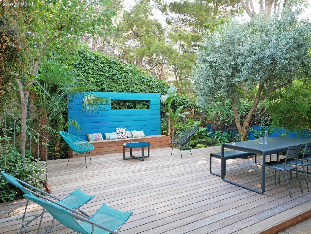 Cette photo montre un petit jardin sur cour exotique avec une exposition partiellement ombragée et une terrasse en bois.