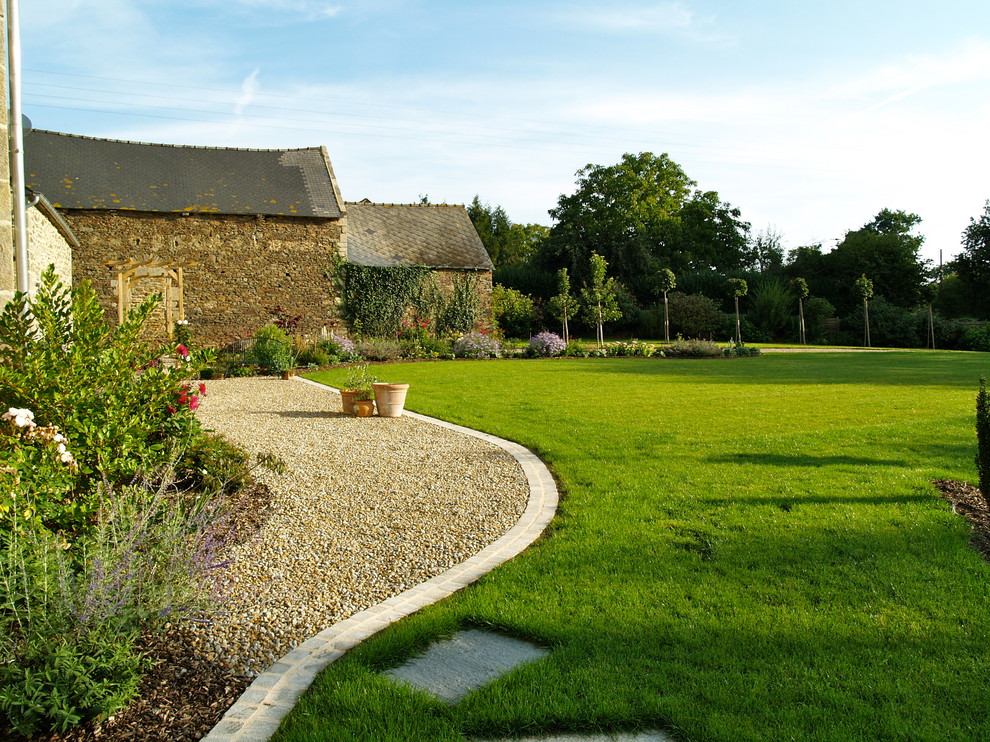 Пример оригинального дизайна: участок и сад на заднем дворе в стиле кантри с покрытием из гравия и газонным бордюром