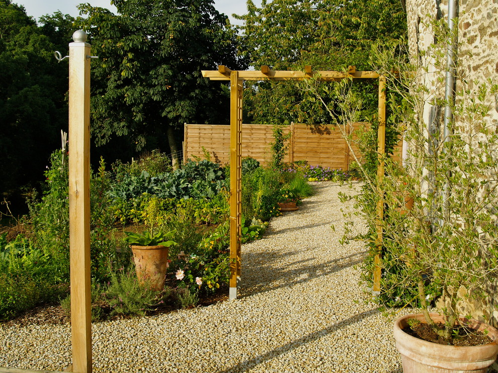 Пример оригинального дизайна: солнечный участок и сад среднего размера на боковом дворе в стиле кантри с хорошей освещенностью и покрытием из гравия
