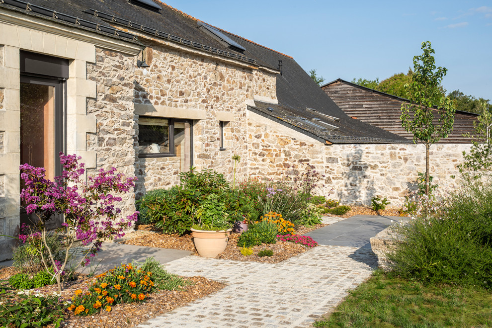 Foto di un giardino country esposto a mezz'ombra di medie dimensioni e davanti casa in primavera con sassi e rocce e pavimentazioni in pietra naturale