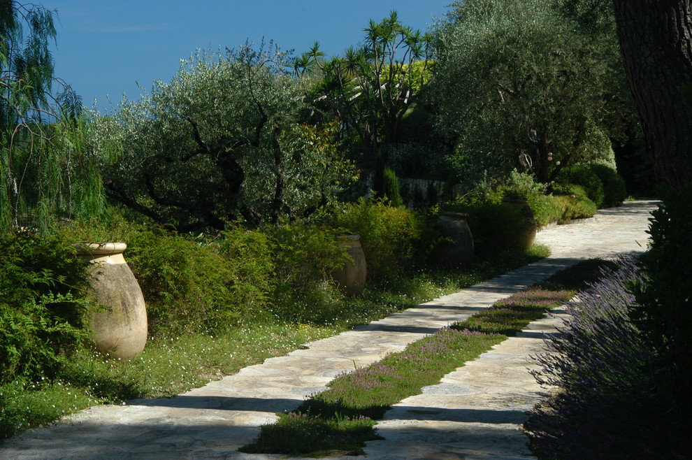 Geräumiger Mediterraner Garten mit Auffahrt, Natursteinplatten und Kübelpflanzen in Nizza