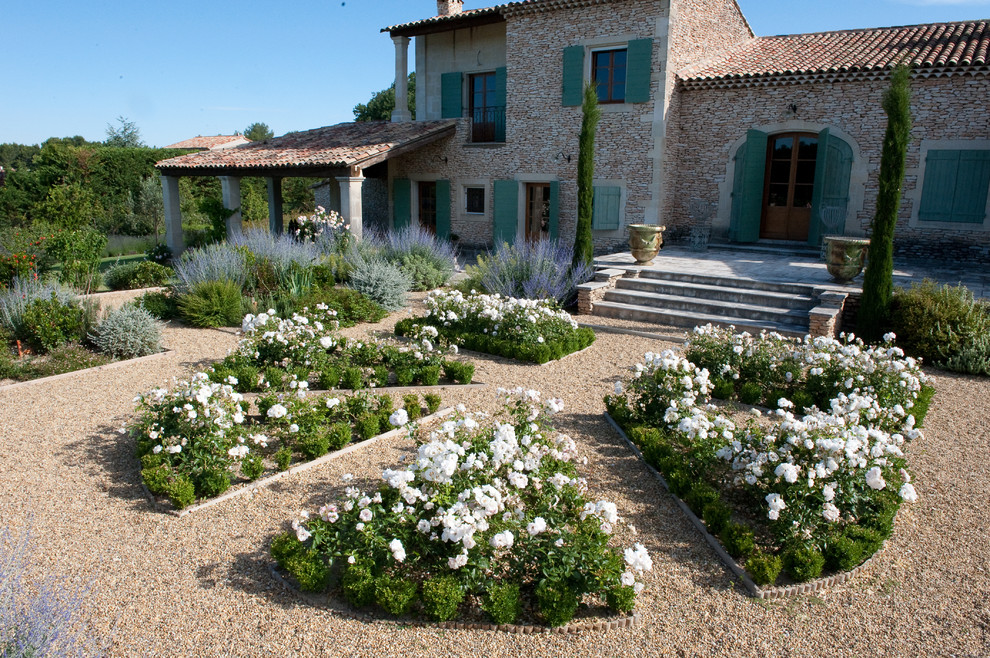 Inspiration for a large mediterranean full sun backyard gravel landscaping in Other for summer.