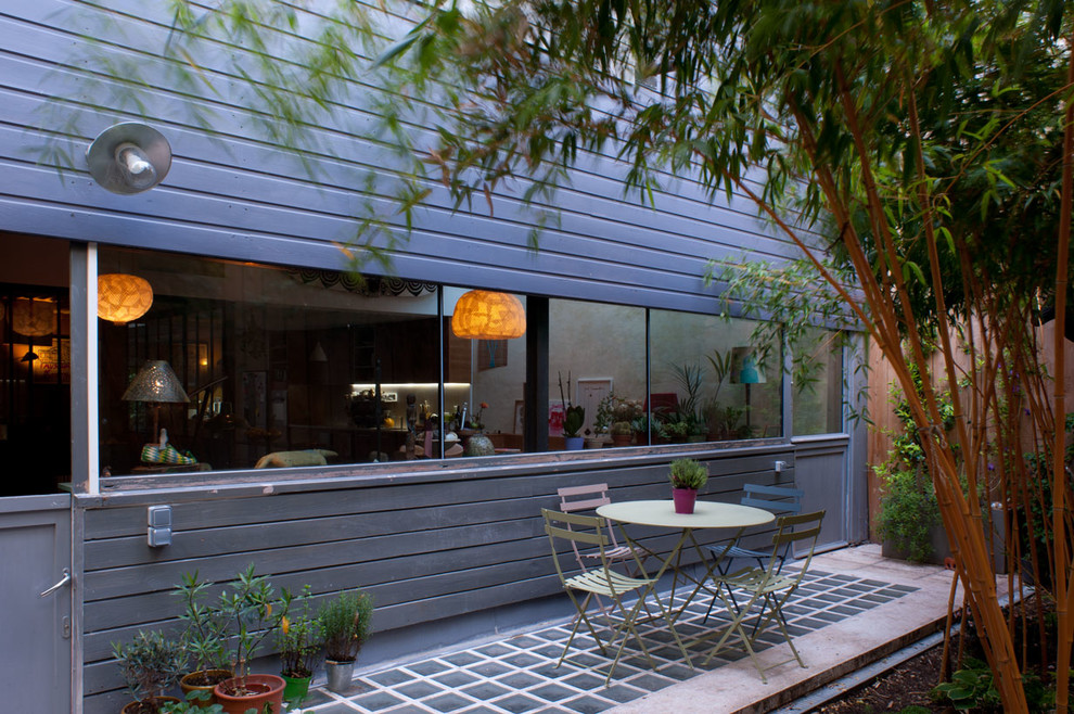 Réalisation d'un jardin arrière design de taille moyenne avec une terrasse en bois.