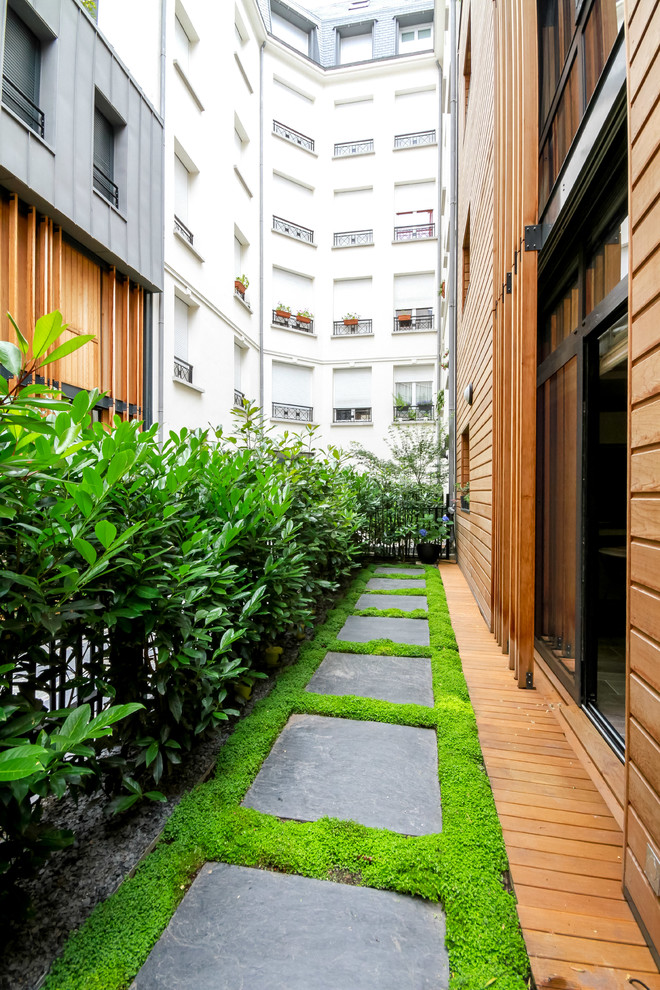 Свежая идея для дизайна: летний участок и сад среднего размера на боковом дворе в современном стиле с перегородкой для приватности, полуденной тенью, мощением тротуарной плиткой и с деревянным забором - отличное фото интерьера