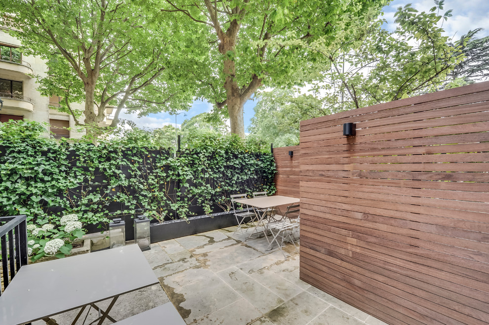 Idee per un piccolo giardino formale minimal esposto a mezz'ombra davanti casa in primavera con ghiaia e recinzione in legno