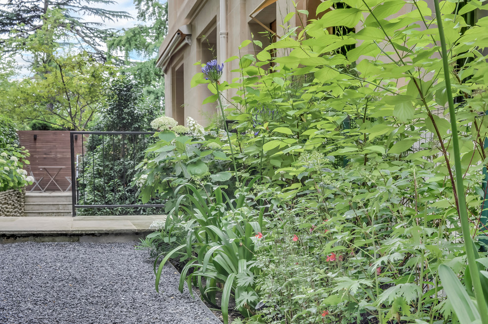 Idee per un piccolo giardino formale contemporaneo esposto a mezz'ombra davanti casa in primavera con un ingresso o sentiero, ghiaia e recinzione in pietra