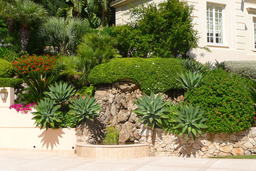 Cette photo montre un jardin méditerranéen avec un point d'eau et des pavés en pierre naturelle.