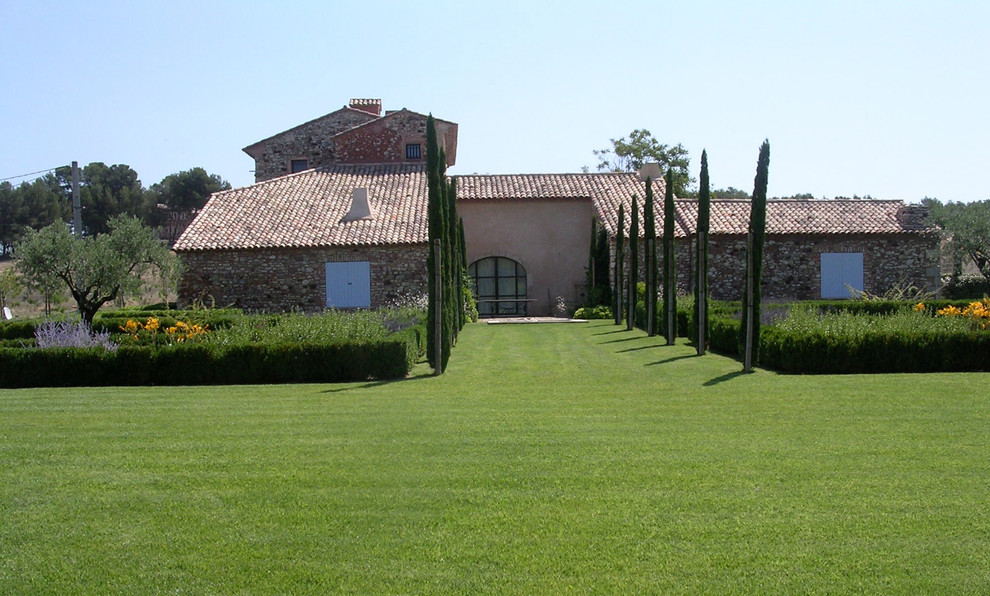 Foto di un ampio giardino formale mediterraneo esposto in pieno sole dietro casa in estate con un ingresso o sentiero