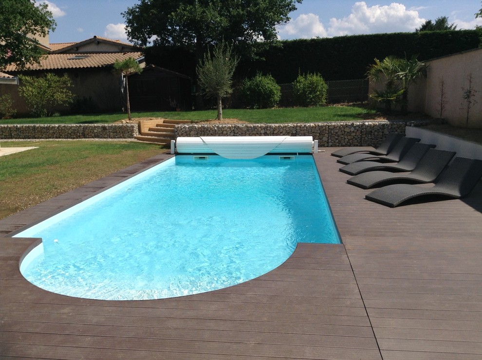 Inspiration för en stor funkis anpassad pool på baksidan av huset, med trädäck