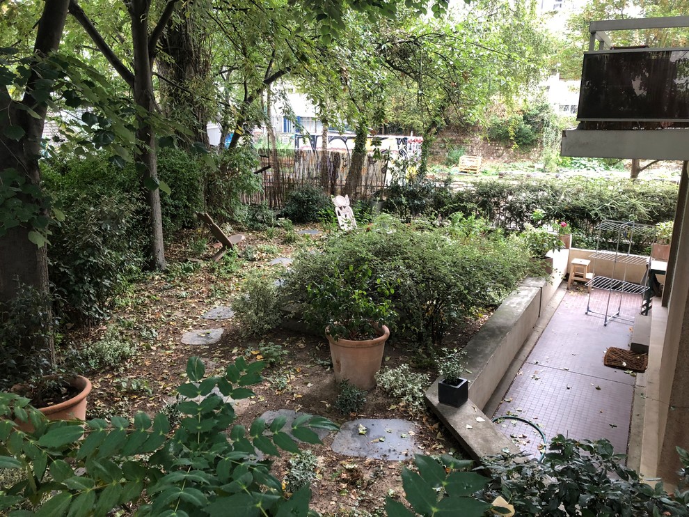 Kleiner, Halbschattiger Rustikaler Dachgarten im Sommer mit Kübelpflanzen und Natursteinplatten in Paris