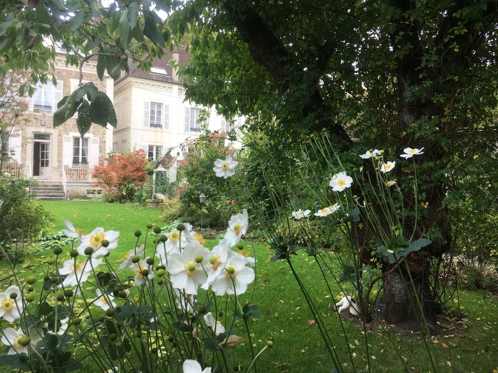 Mittelgroßer, Geometrischer Shabby-Look Garten im Frühling, hinter dem Haus mit Kübelpflanzen, direkter Sonneneinstrahlung und Natursteinplatten in Paris