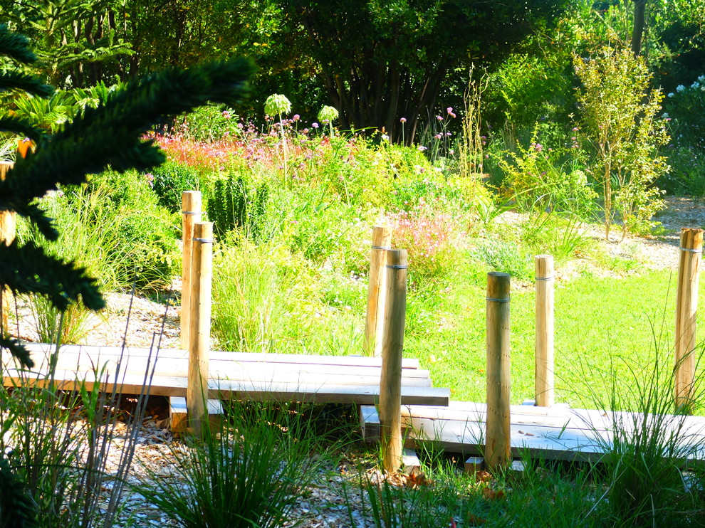Idée de décoration pour un jardin champêtre avec une terrasse en bois.