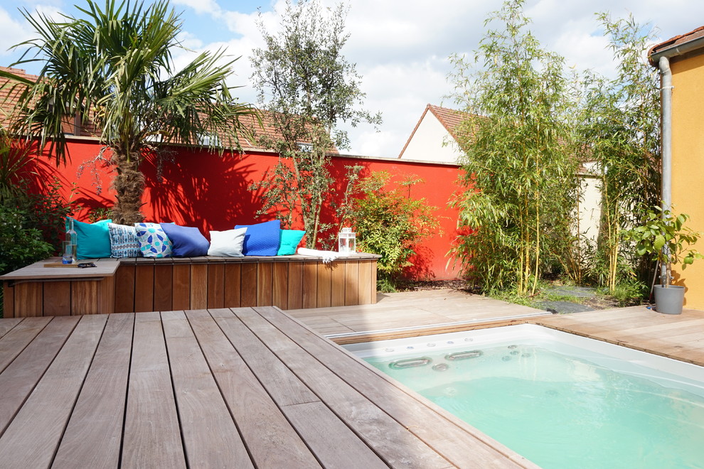 Cette photo montre un jardin arrière tendance de taille moyenne avec une exposition ensoleillée et une terrasse en bois.