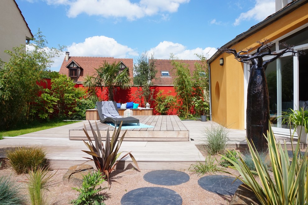 Cette image montre un jardin arrière design de taille moyenne avec une exposition ensoleillée et une terrasse en bois.