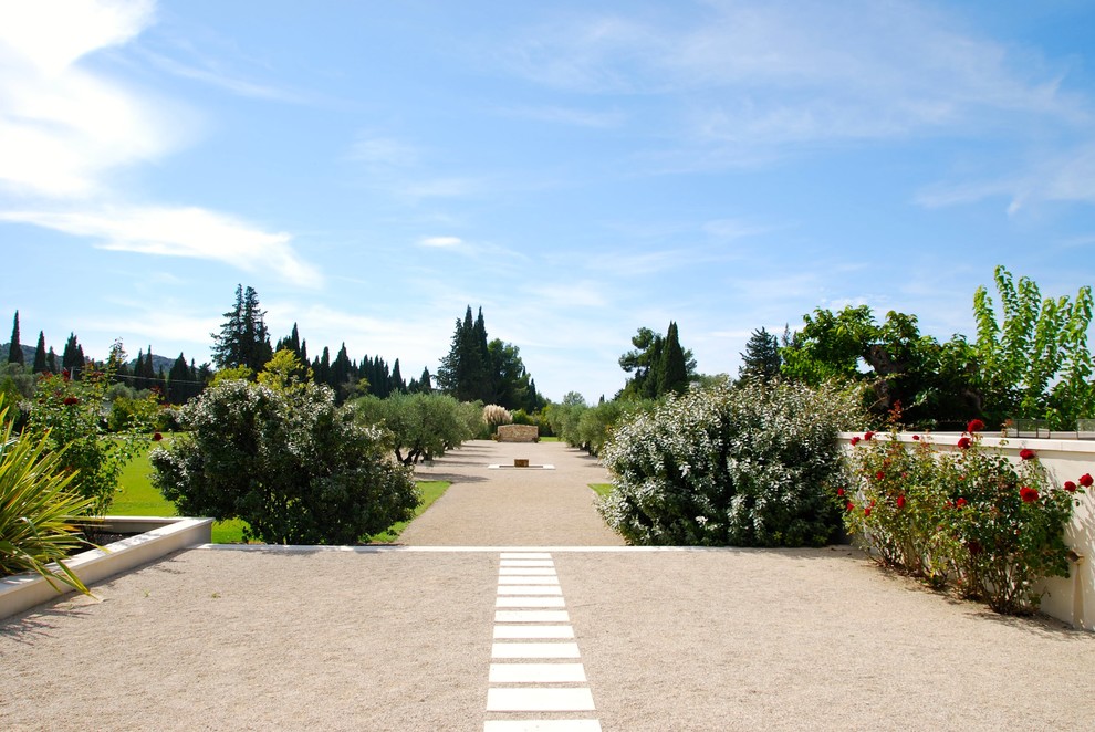 Foto di un ampio giardino mediterraneo esposto in pieno sole dietro casa con un ingresso o sentiero e ghiaia