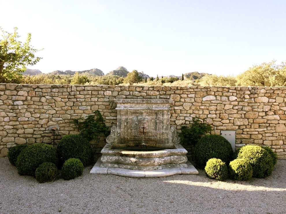 Пример оригинального дизайна: большой садовый фонтан на заднем дворе в средиземноморском стиле с покрытием из гравия