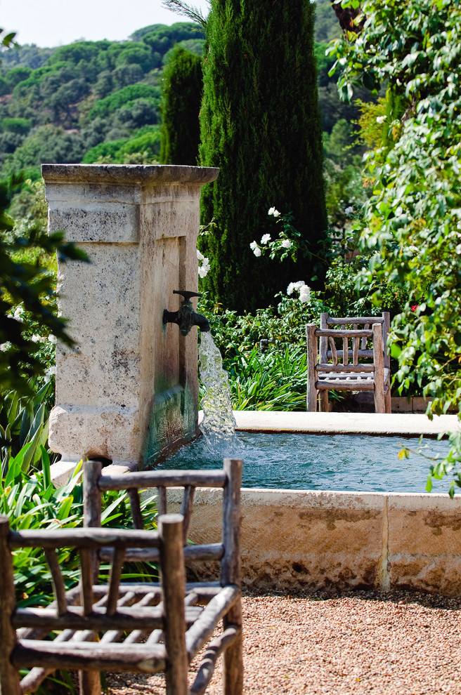 Foto di un grande giardino formale mediterraneo dietro casa con fontane