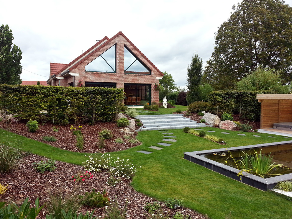 Diseño de jardín contemporáneo extra grande en patio trasero con fuente