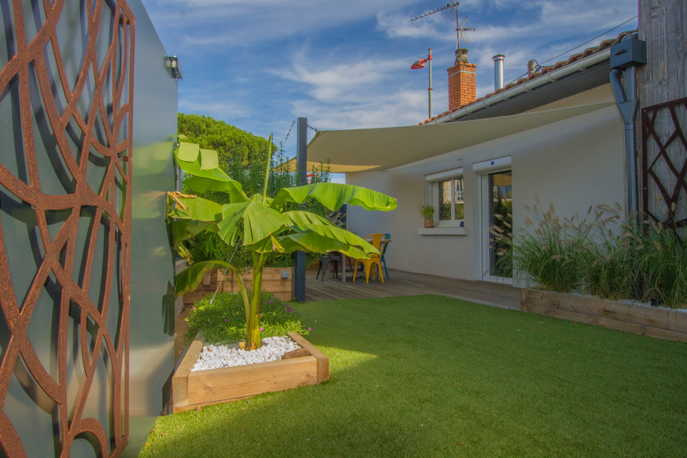 Идея дизайна: летний участок и сад среднего размера на переднем дворе в современном стиле с перегородкой для приватности, полуденной тенью и настилом