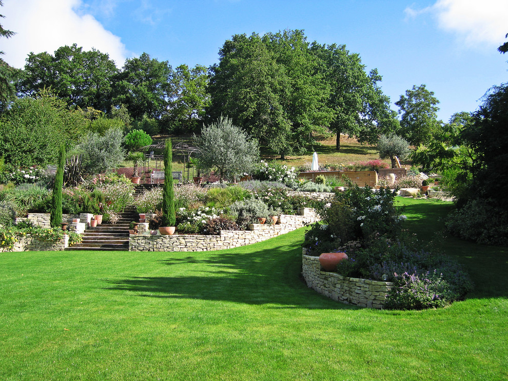 Foto på en mycket stor vintage formell trädgård, med utekrukor och naturstensplattor