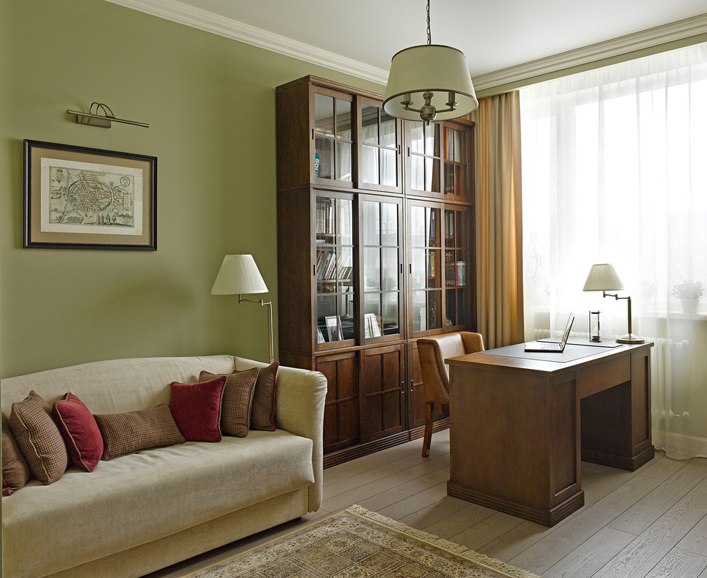 Idee per un ufficio tradizionale di medie dimensioni con pareti verdi, pavimento in legno massello medio, scrivania autoportante e pavimento marrone