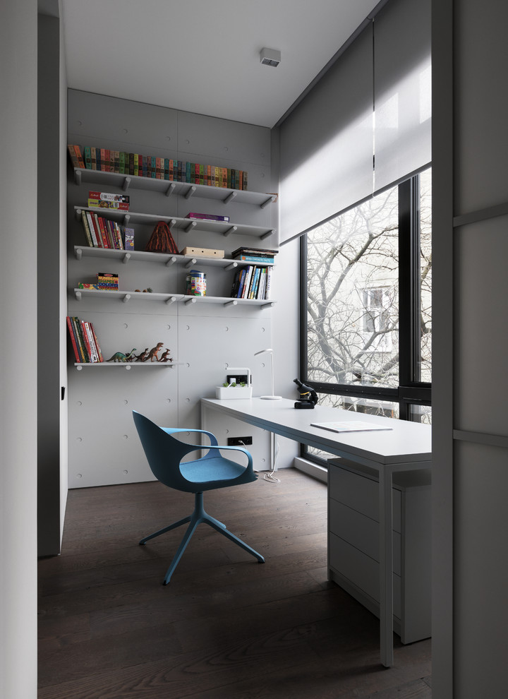 Aménagement d'un bureau contemporain avec un mur blanc, un bureau indépendant et un sol marron.