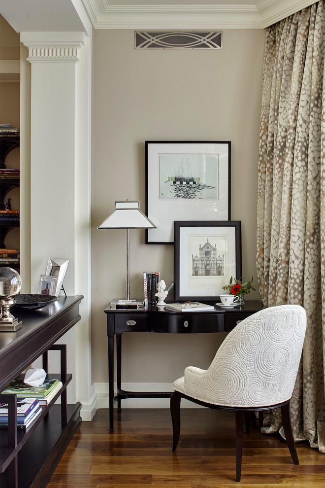 Foto de despacho clásico con paredes beige, suelo de madera en tonos medios, escritorio independiente y suelo marrón