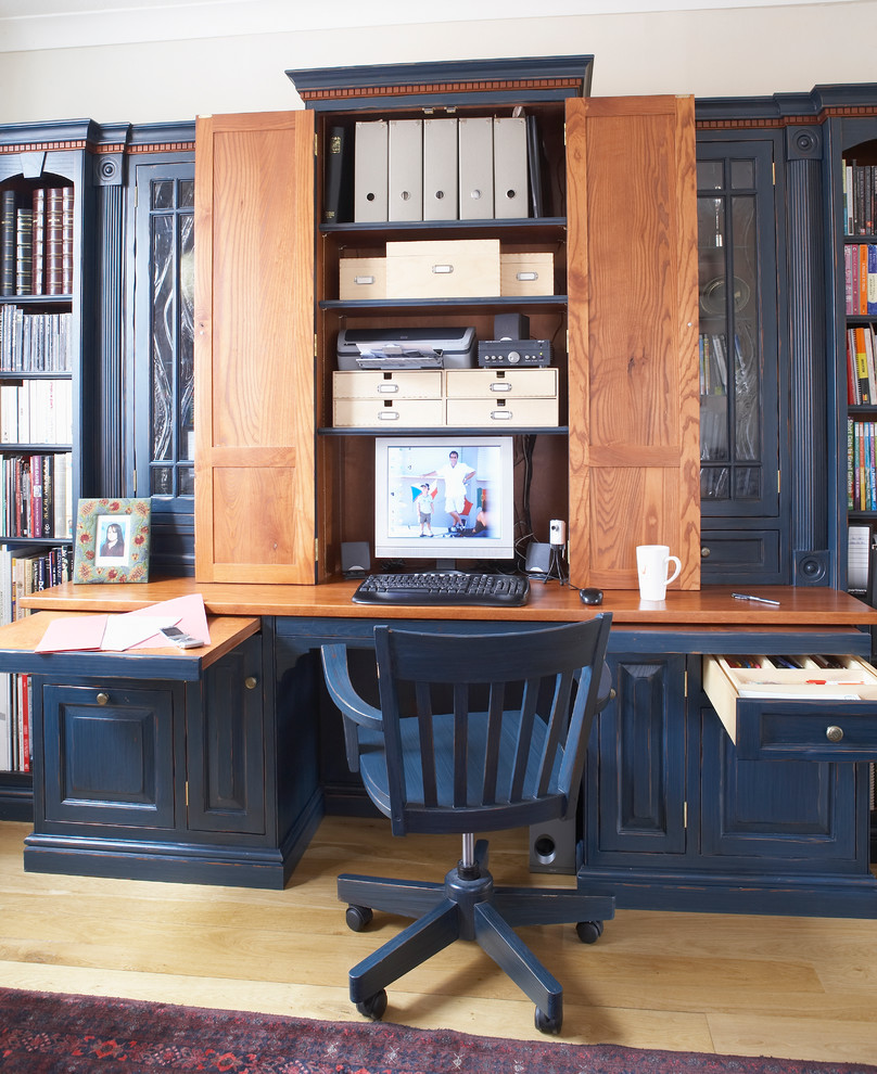 Klassisk inredning av ett arbetsrum, med ljust trägolv och ett inbyggt skrivbord