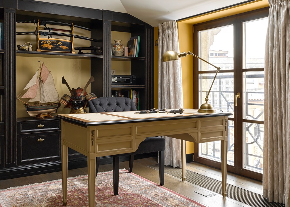 Aménagement d'un petit bureau classique avec un bureau indépendant, un mur jaune et un sol en bois brun.