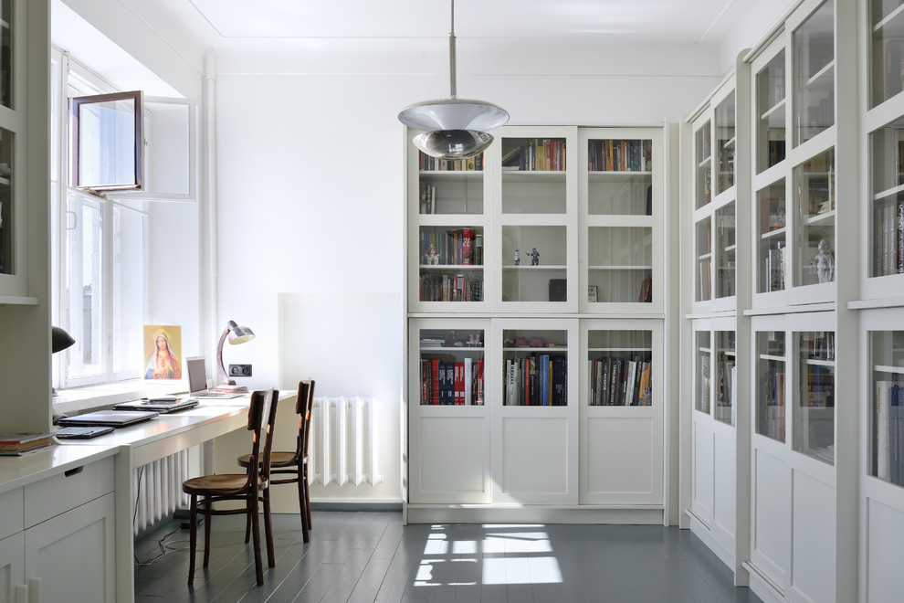 Стильный дизайн: кабинет в современном стиле с встроенным рабочим столом, белыми стенами, деревянным полом и серым полом - последний тренд