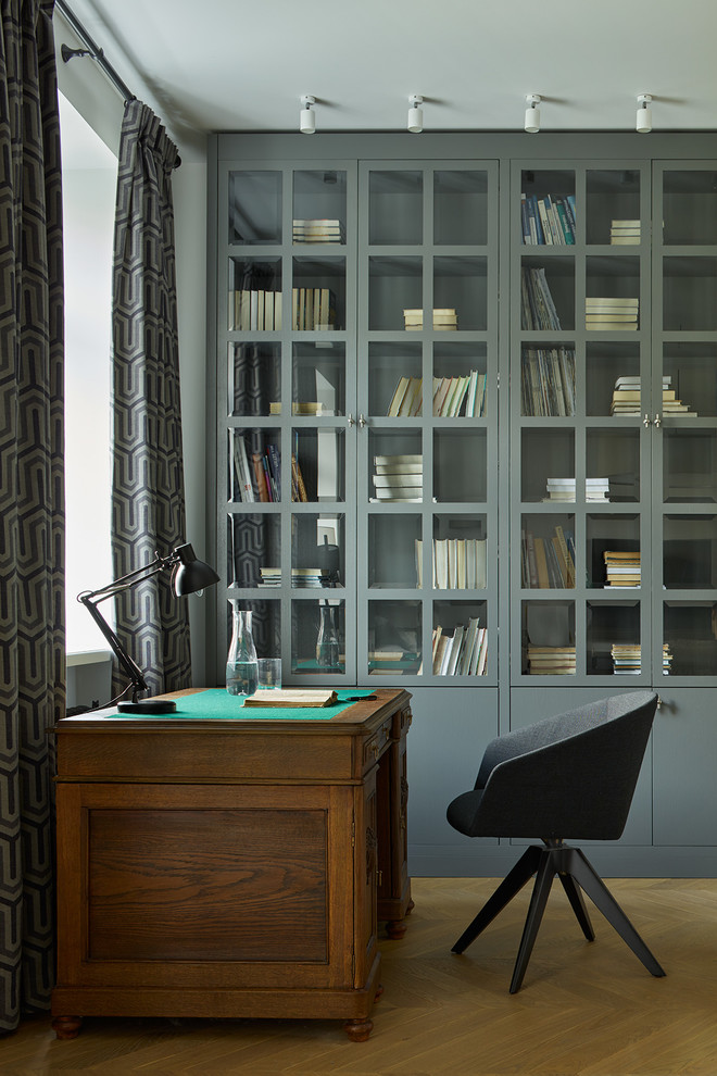 Modelo de despacho tradicional renovado de tamaño medio con escritorio independiente, suelo de madera en tonos medios y suelo marrón