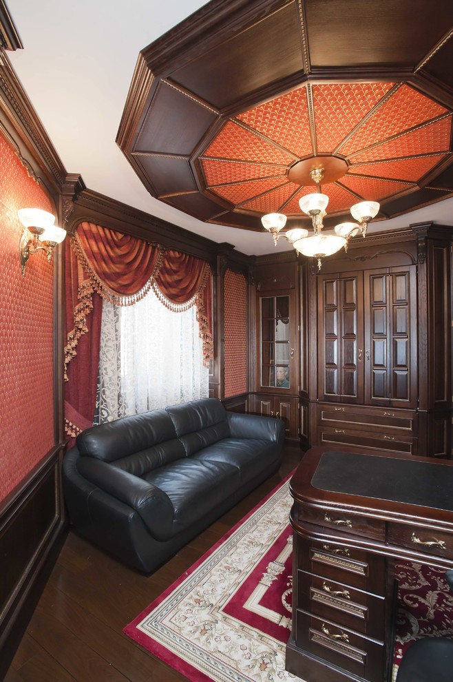 マラガにある高級な小さなトランジショナルスタイルのおしゃれな書斎 (赤い壁、濃色無垢フローリング、自立型机、茶色い床) の写真
