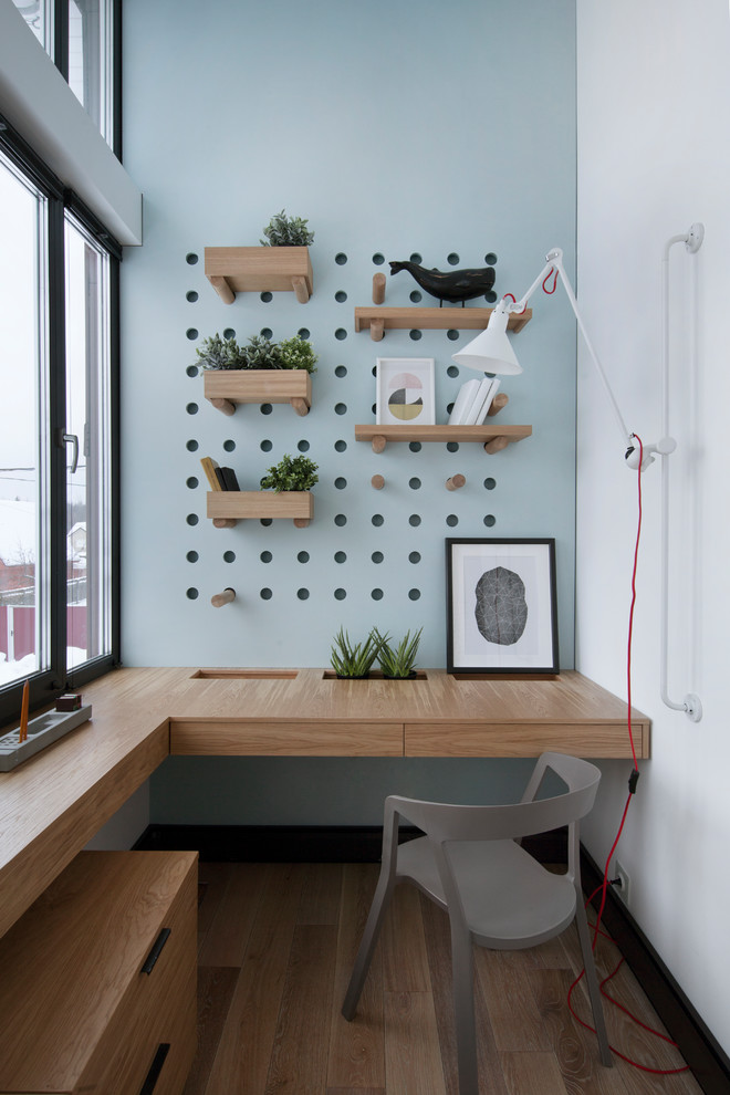 Exemple d'un bureau tendance avec un mur blanc, un sol en bois brun, un bureau intégré et un sol marron.