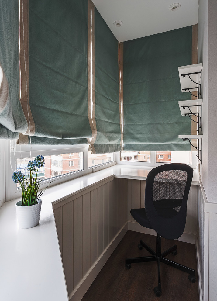 Immagine di un ufficio design con parquet scuro, scrivania incassata e pareti bianche