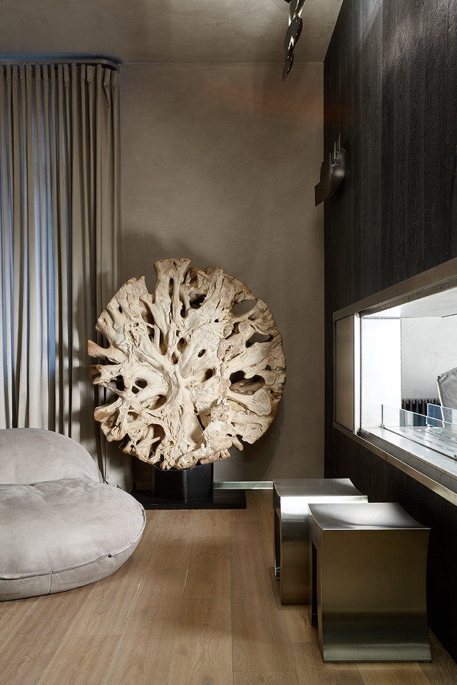 Imagen de despacho actual de tamaño medio con paredes grises, marco de chimenea de madera, chimenea de doble cara, suelo beige y suelo de madera clara