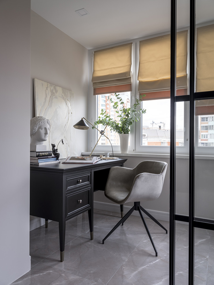 Modelo de despacho tradicional renovado de tamaño medio con paredes grises, escritorio independiente y suelo gris
