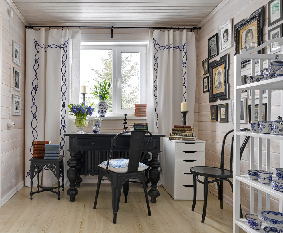 Modelo de despacho romántico con paredes blancas, suelo de madera clara y escritorio independiente