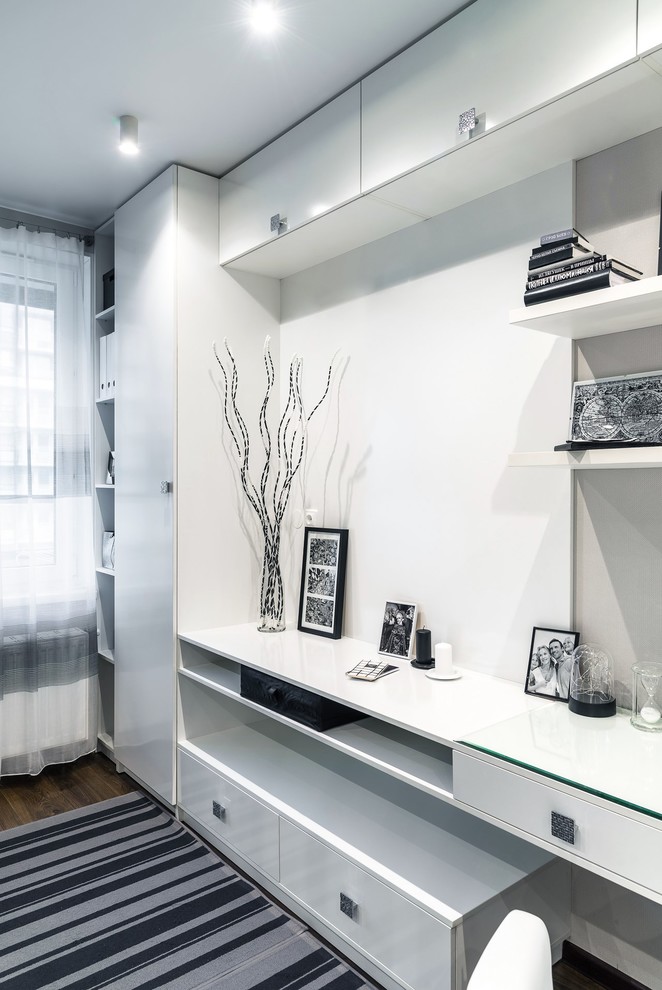 サンクトペテルブルクにある低価格の小さなコンテンポラリースタイルのおしゃれな書斎 (グレーの壁、ラミネートの床、造り付け机、茶色い床) の写真