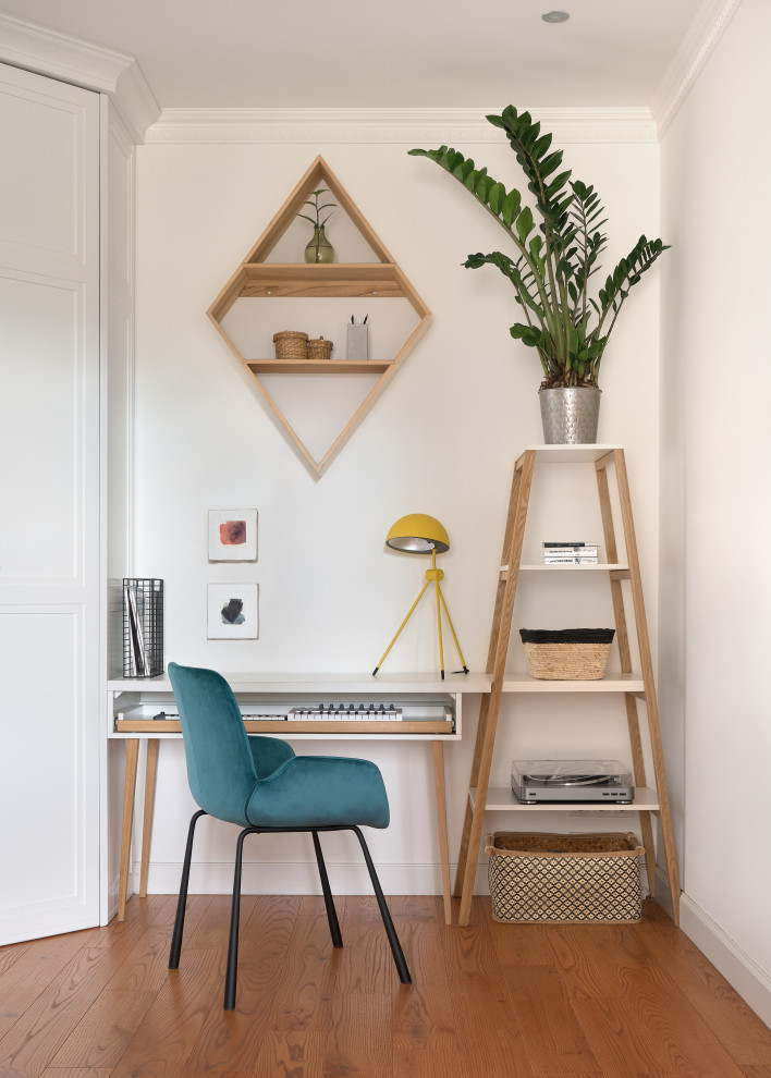 Minimalistisk inredning av ett arbetsrum, med vita väggar, mellanmörkt trägolv, ett fristående skrivbord och brunt golv
