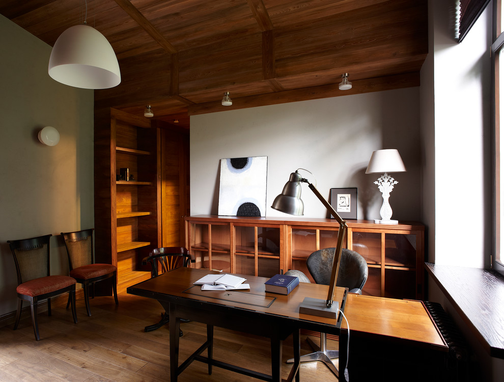 Ispirazione per uno studio contemporaneo di medie dimensioni con pareti grigie, pavimento in legno verniciato, scrivania autoportante e pavimento marrone