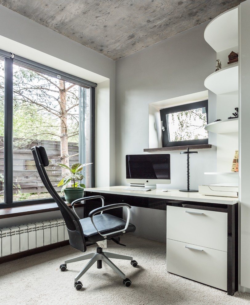 Стильный дизайн: рабочее место в стиле лофт с серыми стенами, ковровым покрытием, отдельно стоящим рабочим столом и бежевым полом - последний тренд