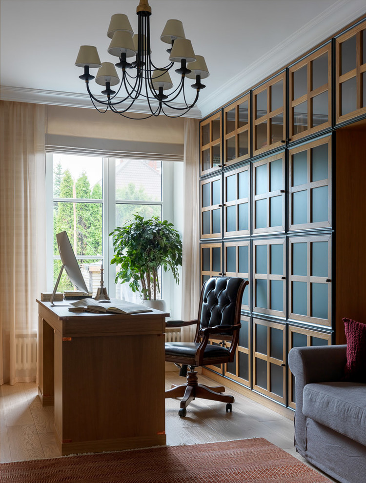 Diseño de despacho clásico renovado con paredes beige, suelo de madera clara, escritorio independiente y suelo beige