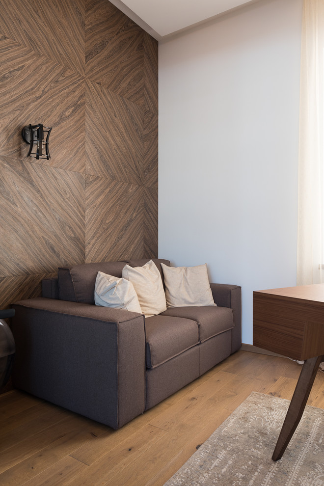 Imagen de despacho escandinavo de tamaño medio con biblioteca, paredes grises, suelo de madera en tonos medios, escritorio independiente y suelo marrón