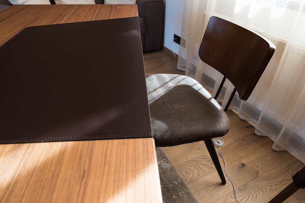 Diseño de despacho escandinavo de tamaño medio con biblioteca, paredes grises, suelo de madera en tonos medios, escritorio independiente y suelo marrón