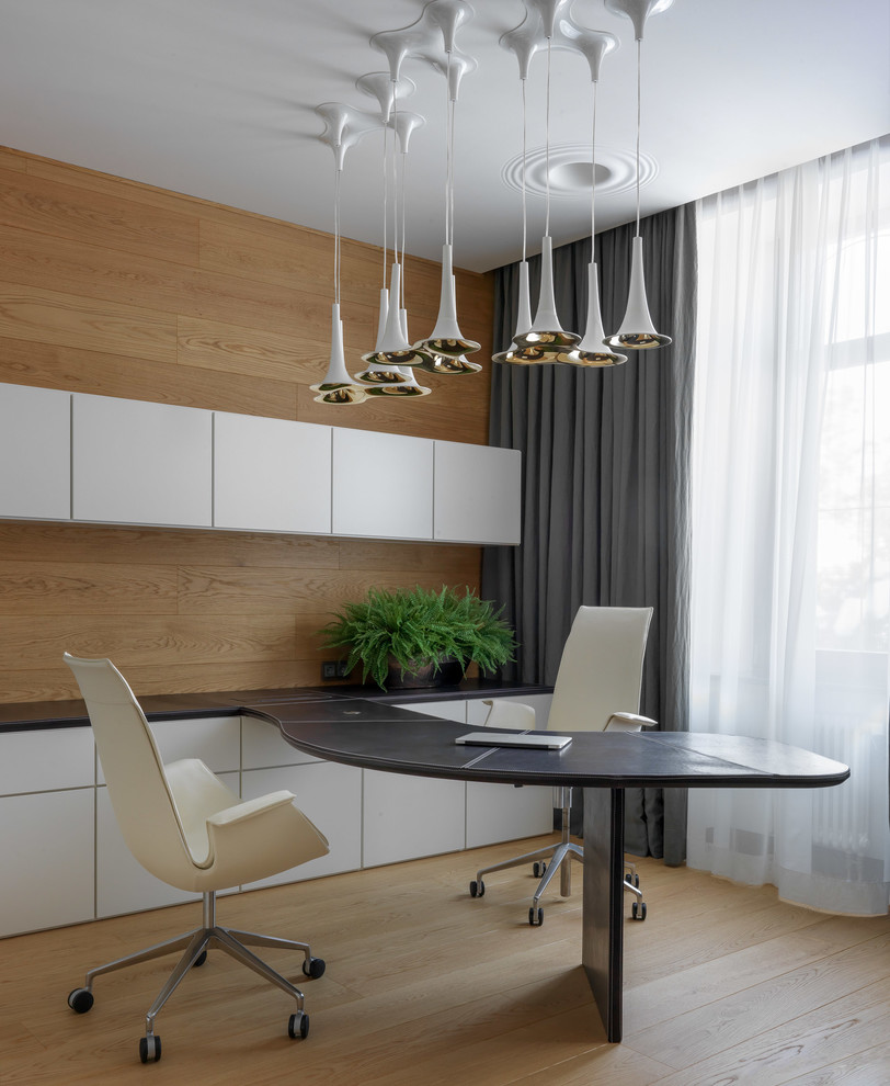 Foto de despacho contemporáneo grande con suelo de madera clara, escritorio empotrado y suelo beige