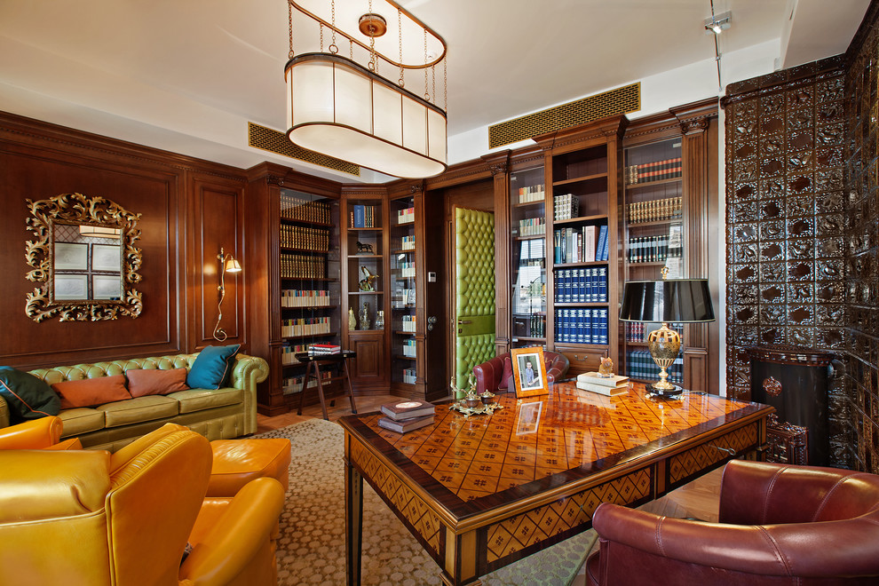 Inspiration för ett mellanstort vintage hemmabibliotek, med bruna väggar, ett fristående skrivbord, en öppen vedspis, mellanmörkt trägolv och en spiselkrans i trä