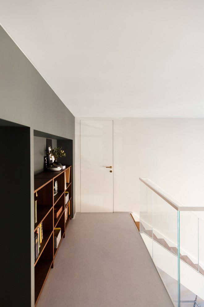 Immagine di uno studio di medie dimensioni con libreria, pareti verdi, pavimento in linoleum, scrivania autoportante e pavimento grigio