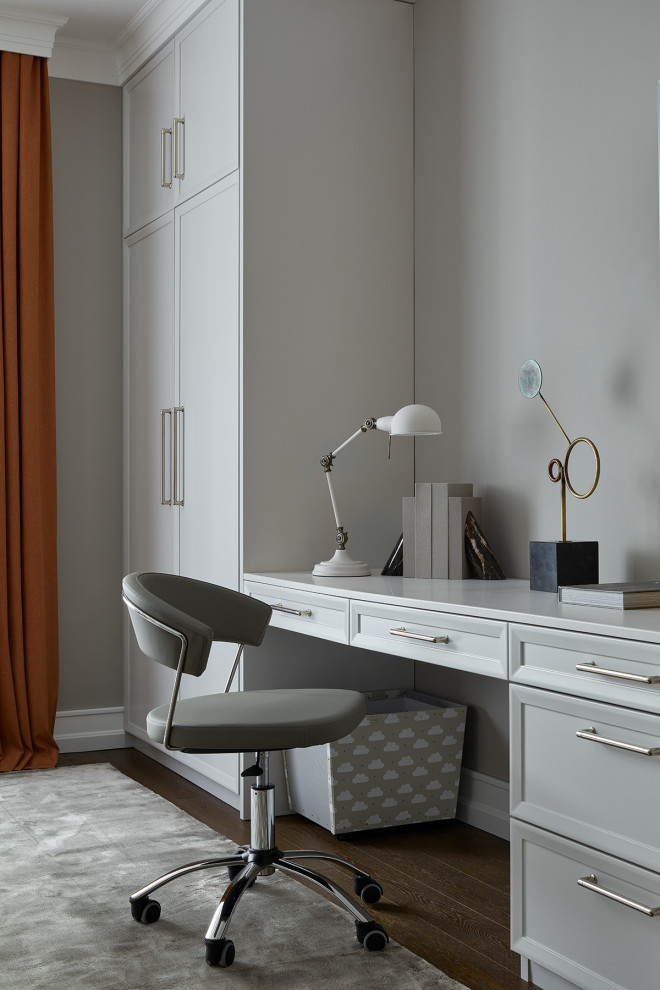 Imagen de despacho clásico con paredes grises, suelo de madera oscura y escritorio empotrado