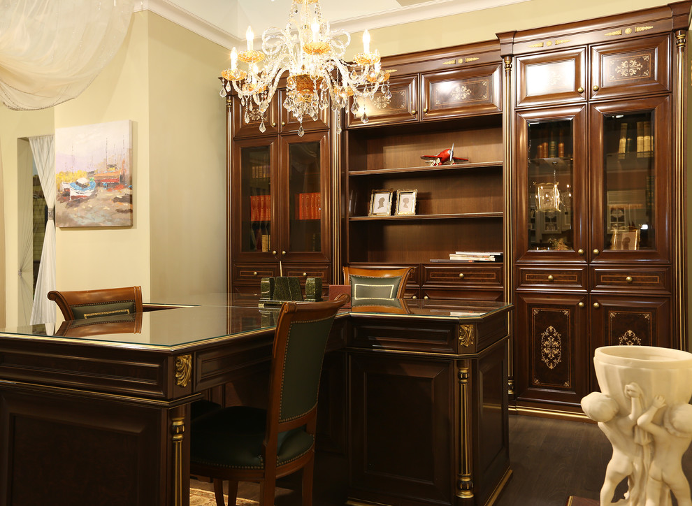 Diseño de sala de manualidades tradicional grande con paredes beige, suelo de madera en tonos medios, escritorio independiente y suelo marrón