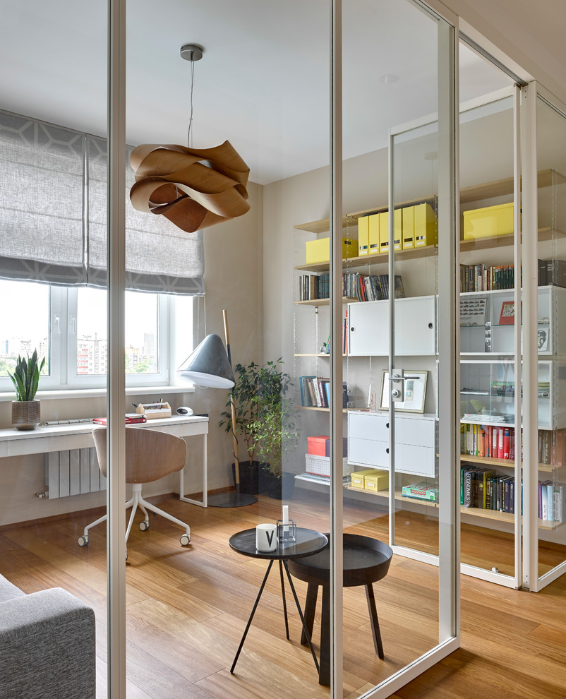 Источник вдохновения для домашнего уюта: рабочее место в скандинавском стиле с бежевыми стенами, деревянным полом, отдельно стоящим рабочим столом и коричневым полом